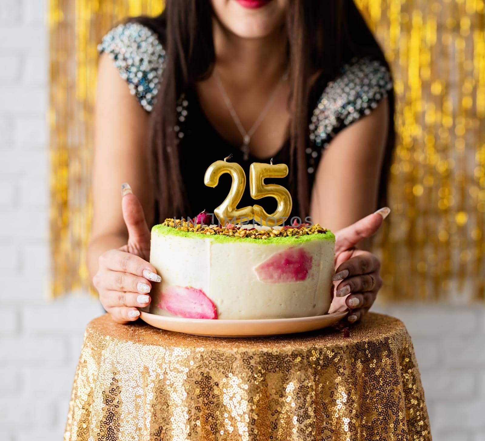 Birthday party. Attractive caucasian woman in black party dress ready to eat birthday cake celebrating her twenty fifth birthday