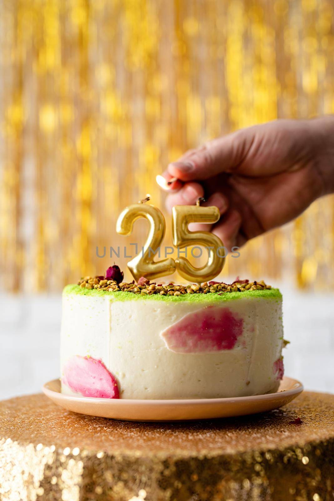 woman hand lighting the candles on the cake by Desperada