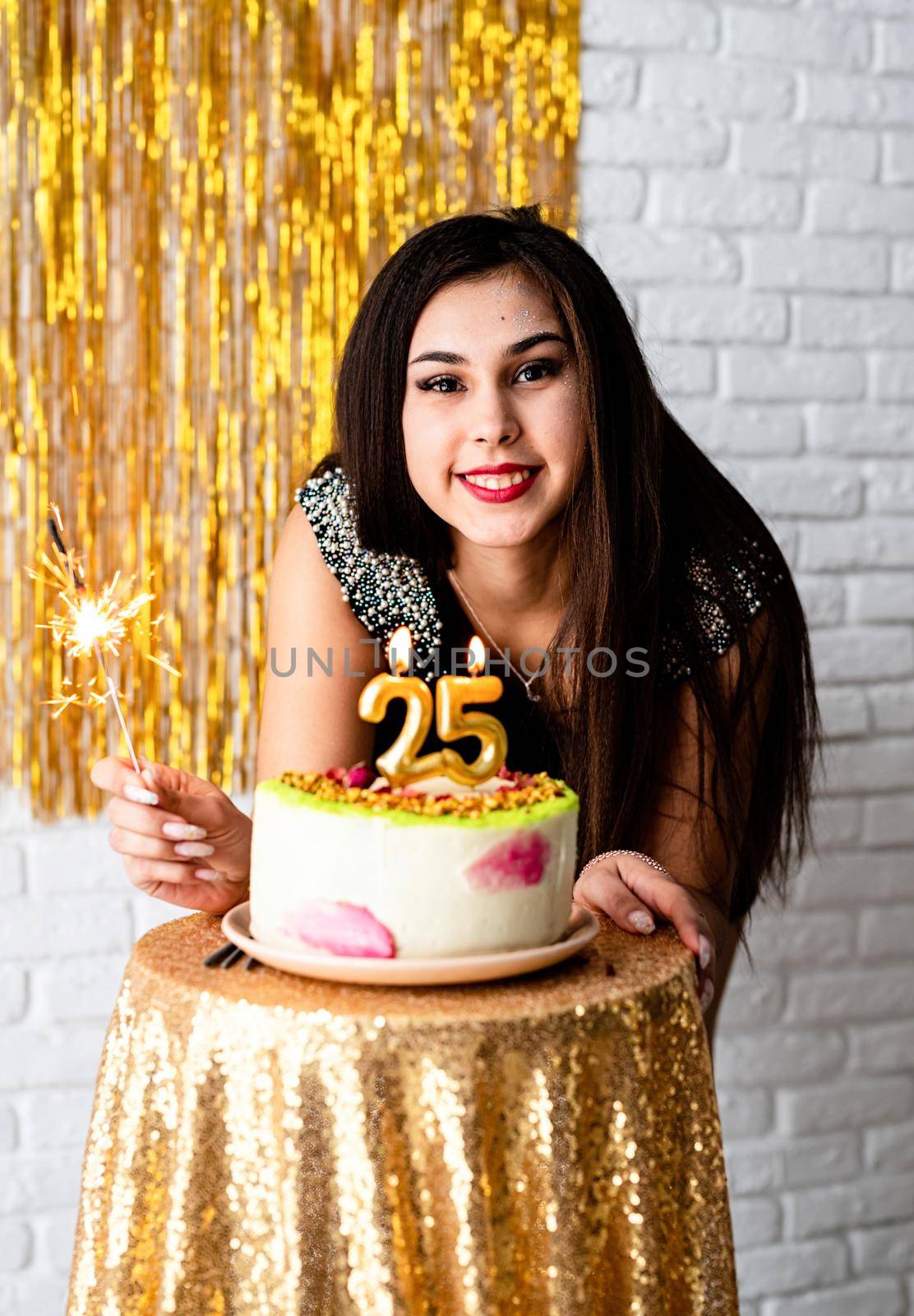 Birthday party. Attractive caucasian woman in black party dress ready to eat birthday cake celebrating her twenty fifth birthday