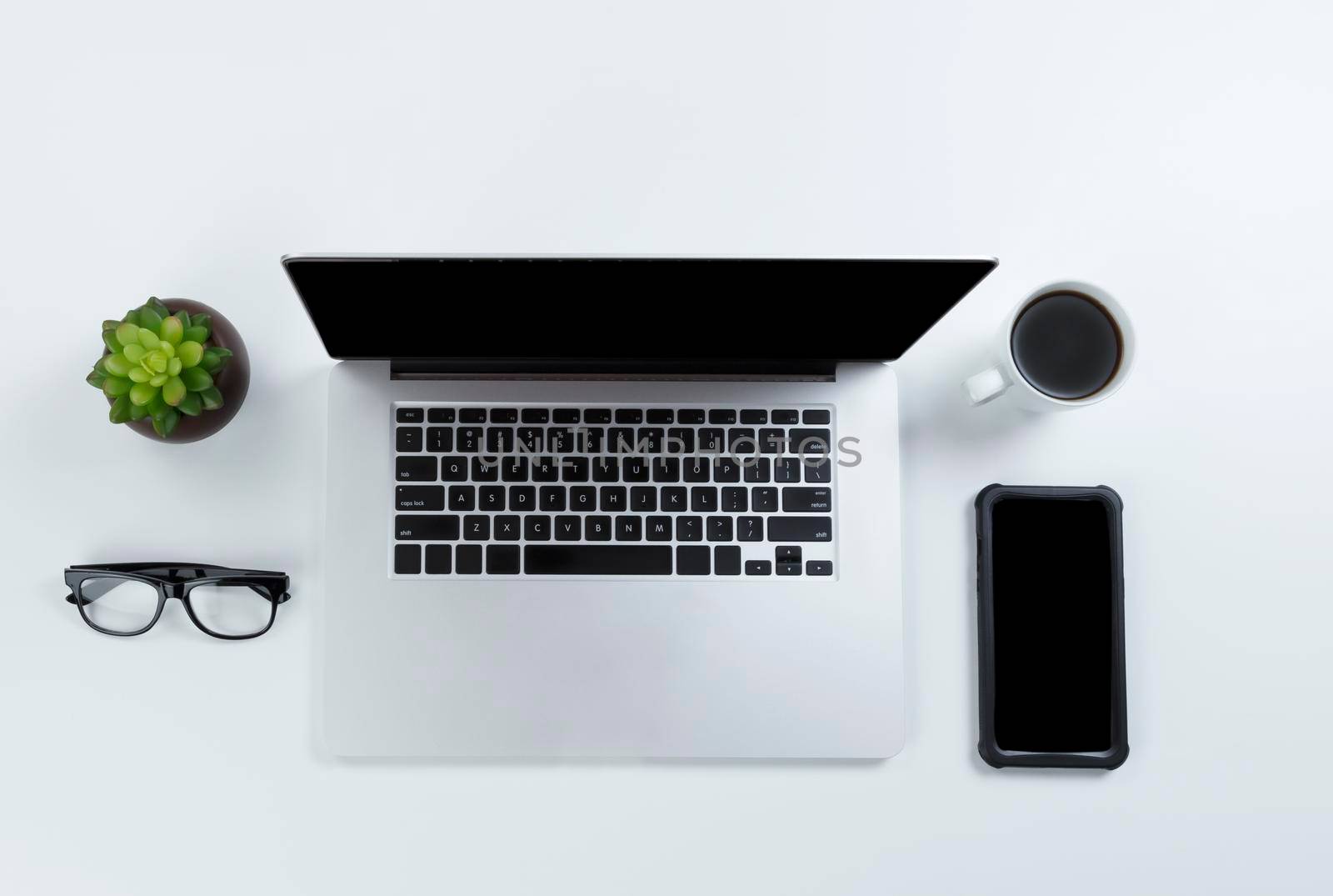 Office desk table with laptop computer, coffee and smartphone. Overhead with copy space available in flat lay format. 