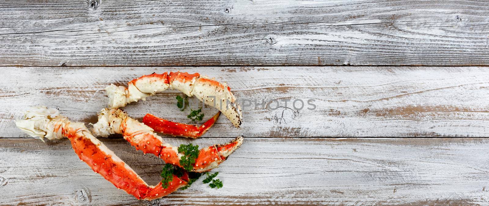 King crab claws and legs on white rustic wood in flat lay format 
