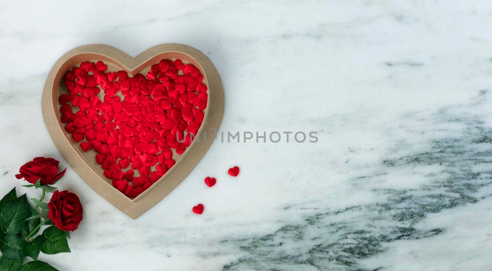 Happy Valentines Day with lovely red rose flowers and heart shaped giftbox filled with tiny hearts on natural marble stone  by tab1962