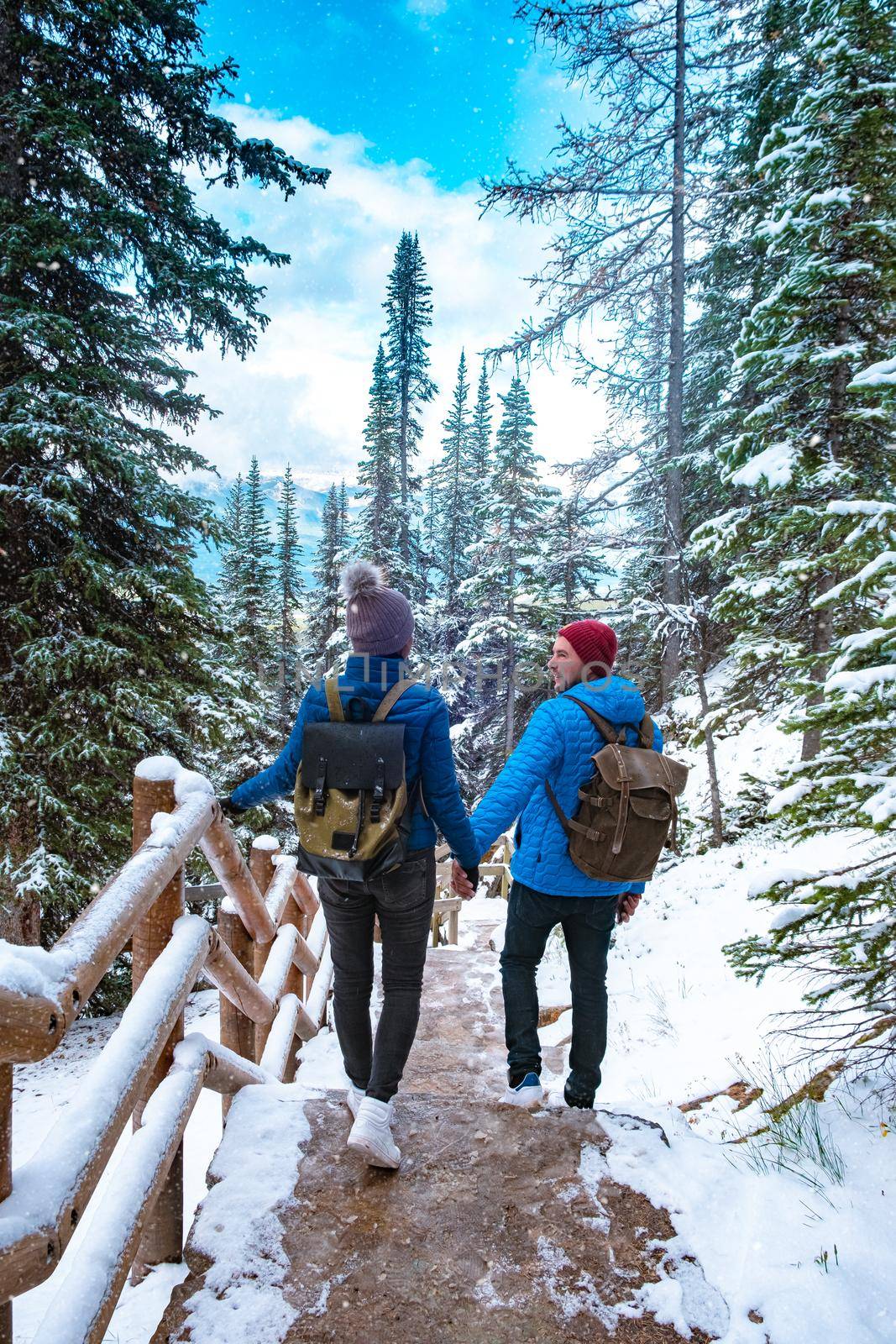 Lake Agnes Canada near Lake Louise Canada Alberta. Couple hiking in the forest with snow by Lake Louise Canada Alberta by fokkebok