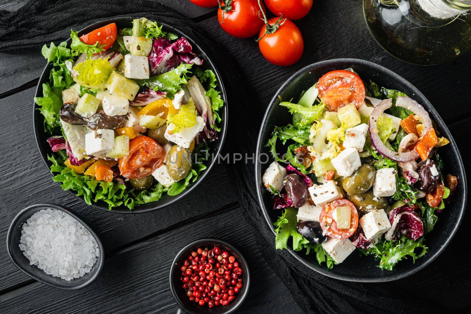 Greek salad with fresh vegetables, feta cheese and olives kalamati, on black wooden table background, top view flat lay