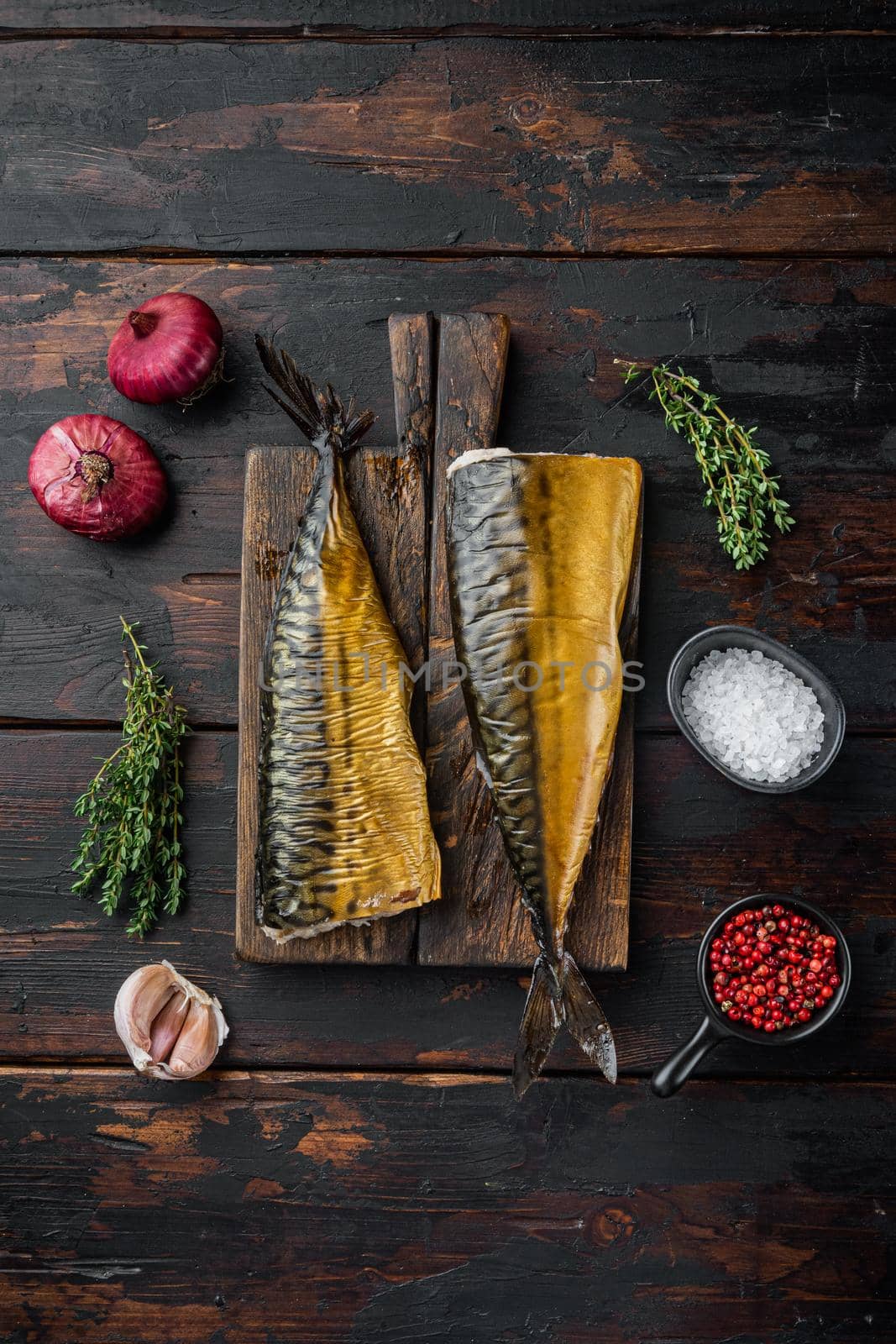 Whole smoked fish mackerel, on old dark wooden table background, top view flat lay
