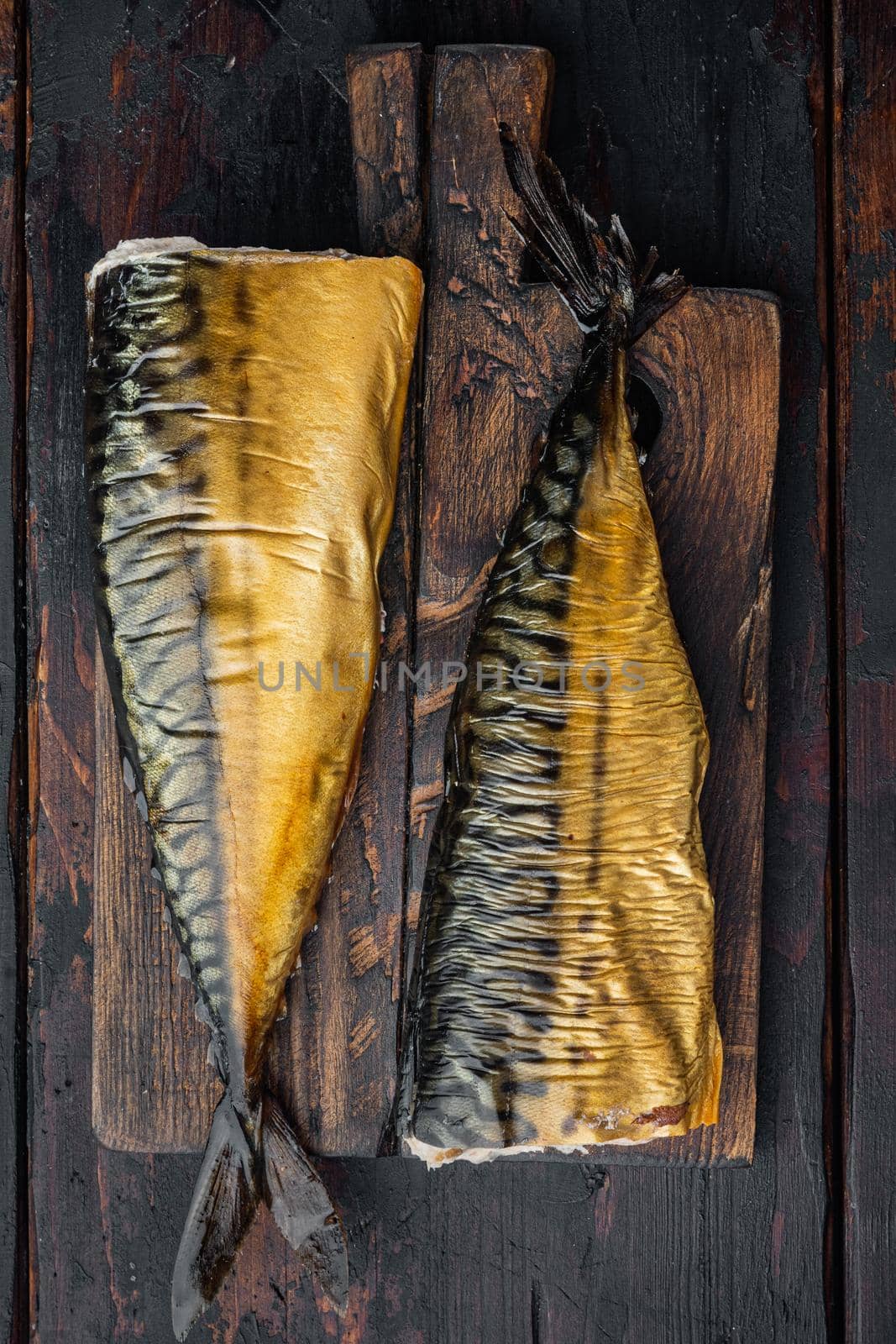 Smoked fish mackerel, on old dark wooden table background, top view flat lay