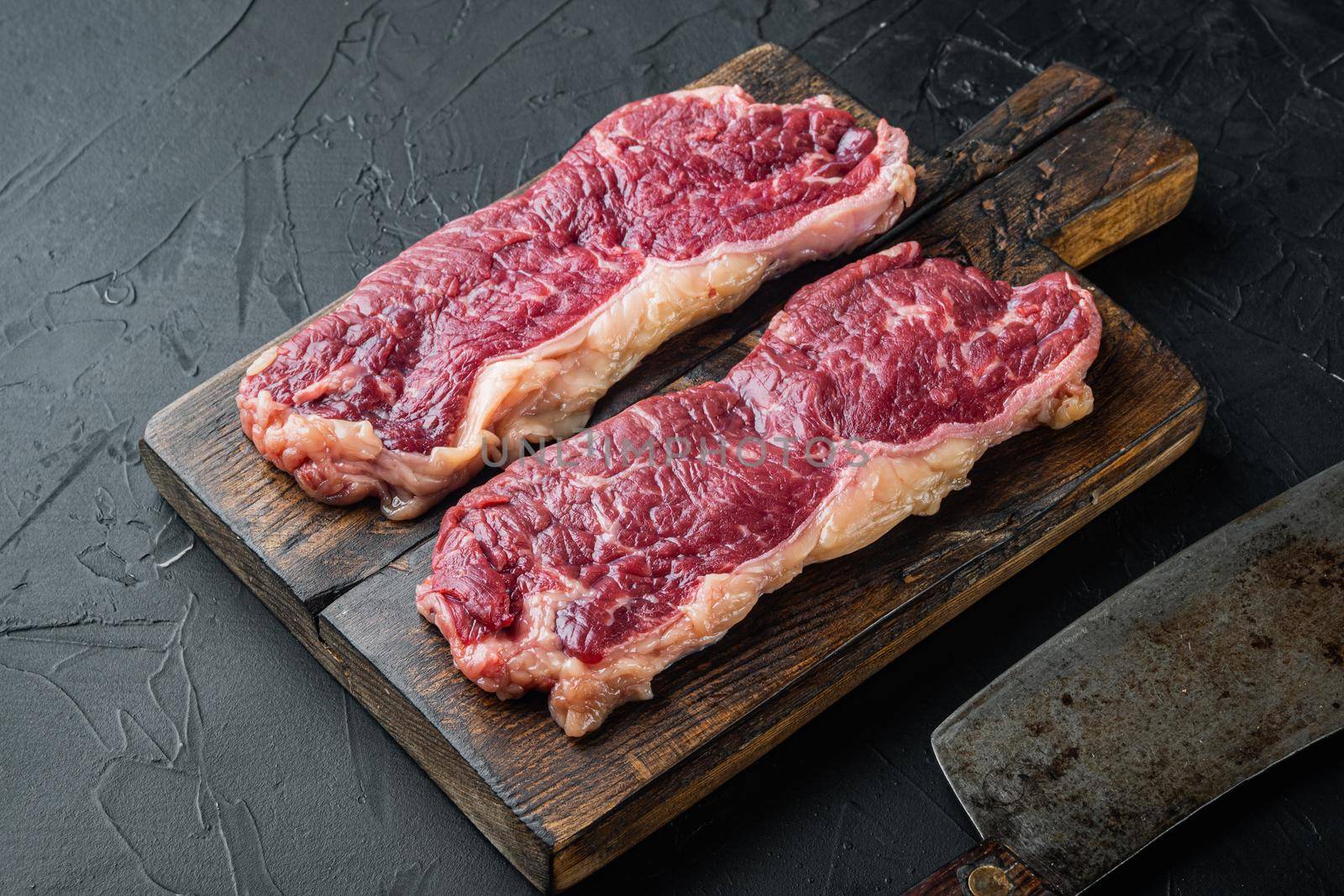 Sliced raw piece of marble beef steak, on black background
