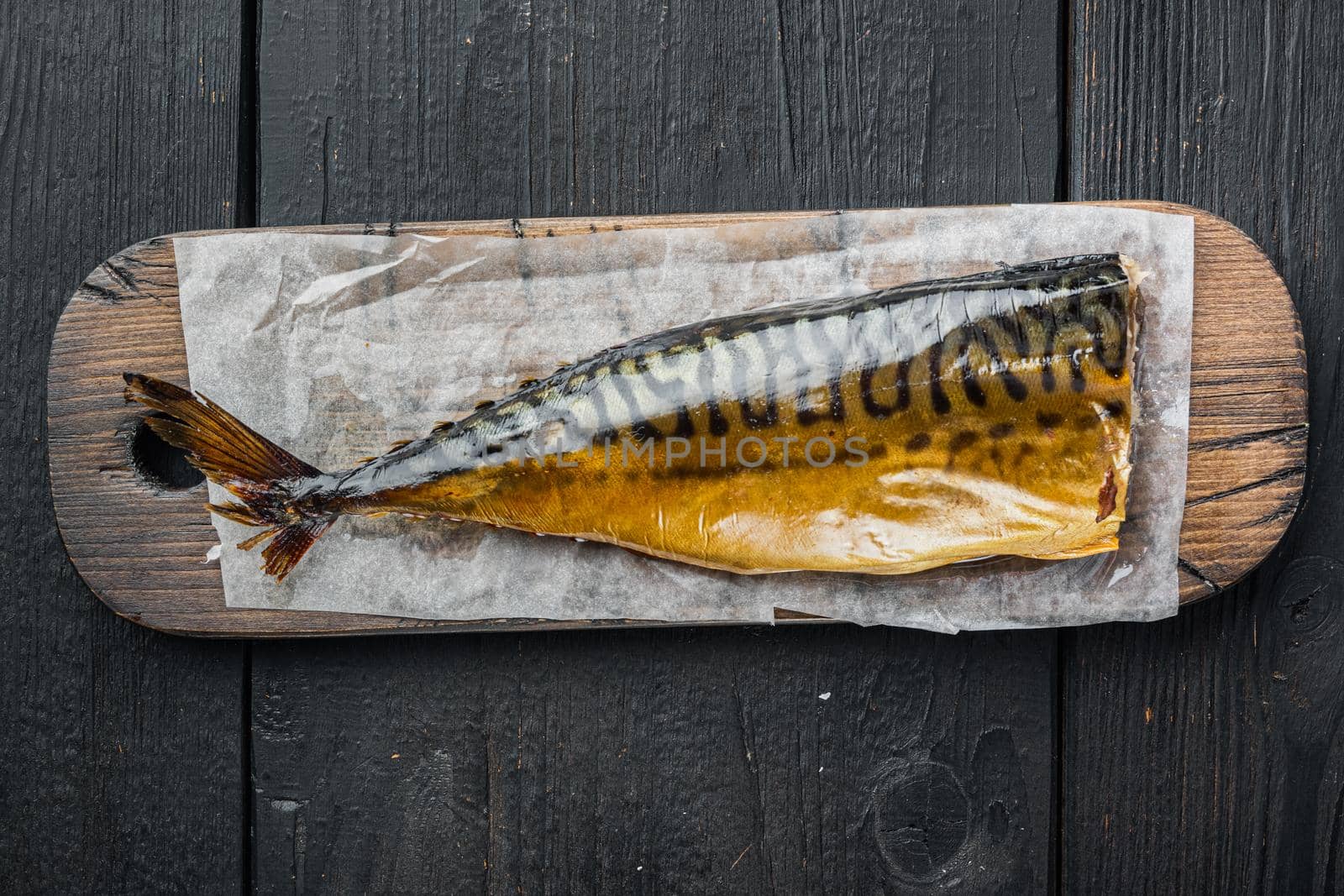 Whole smoked fish mackerel, on black wooden table background, top view flat lay