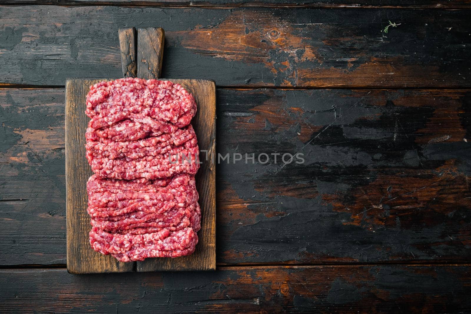 Fresh, minced meat ground beef, on old dark wooden table background, top view flat lay with copy space for text