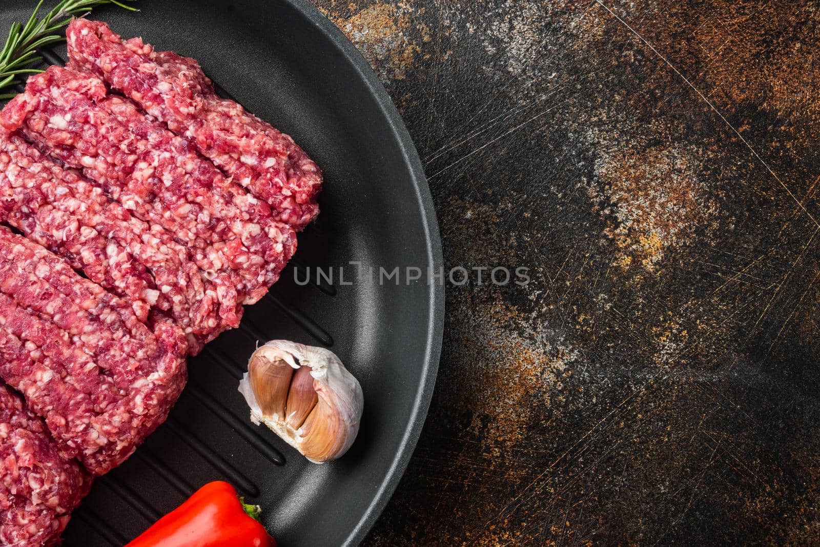 Fresh raw minced beef, ground meat, on old dark rustic background, top view flat lay with copy space for text