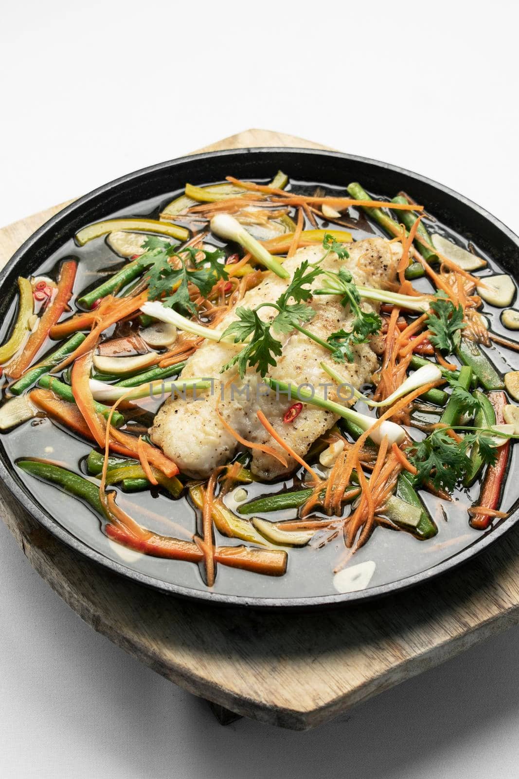 chinese style steamed fish fillet with vegetables on hot plate by jackmalipan