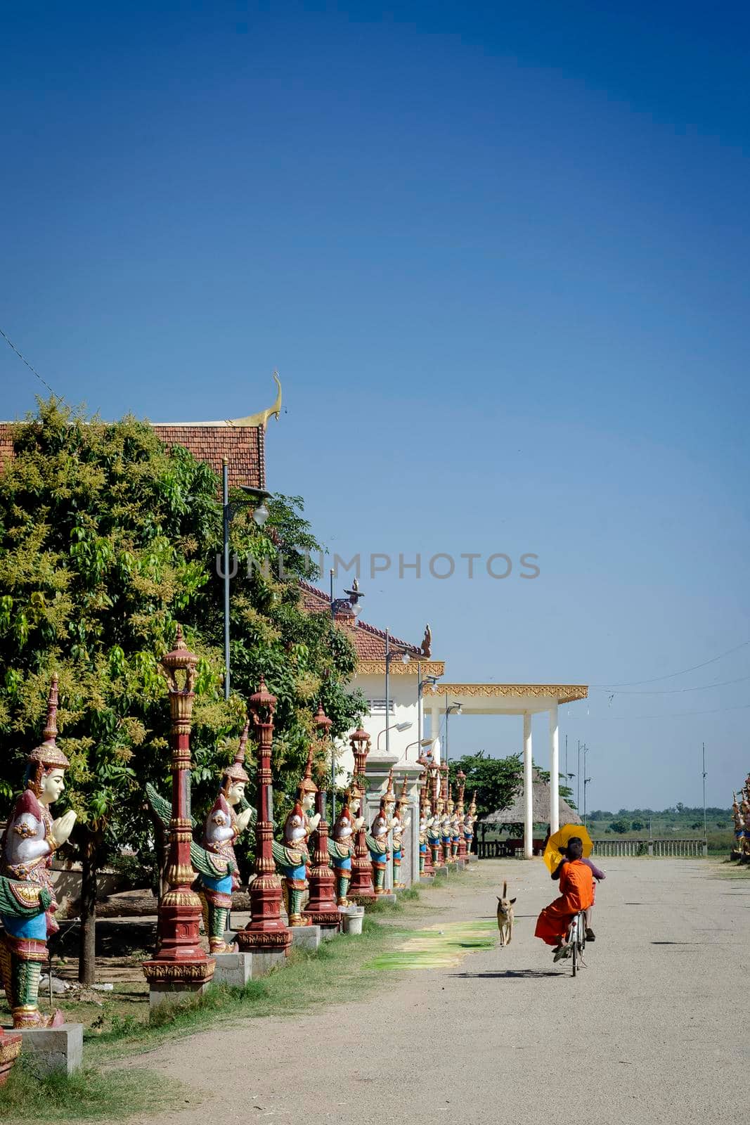 buddhist monk walking outside Wat Svay Andet Pagoda in Kandal Province Cambodia by jackmalipan
