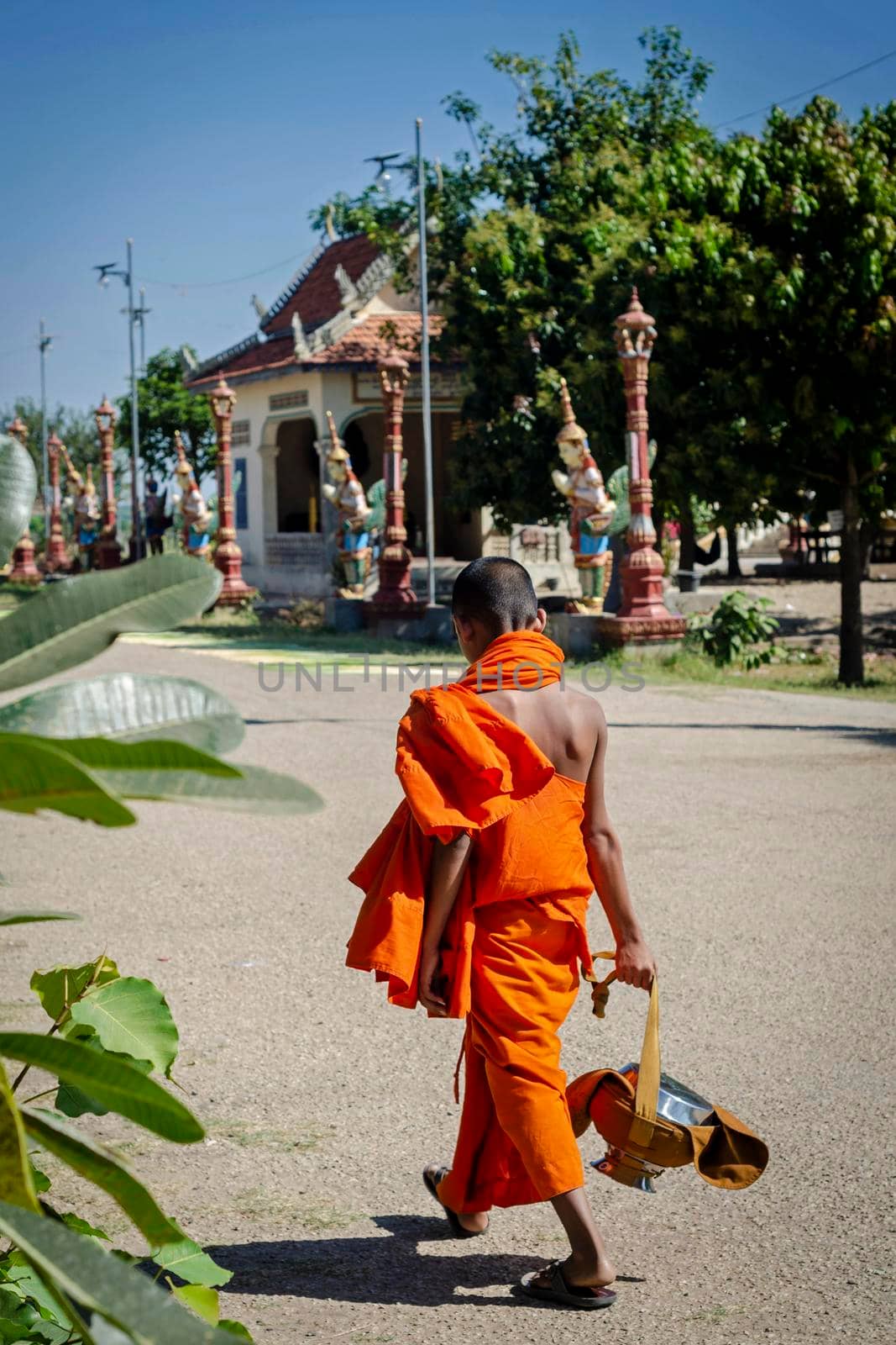 buddhist monk street scene walking outside Wat Svay Andet Pagoda UNESCO site in Kandal Province Cambodia