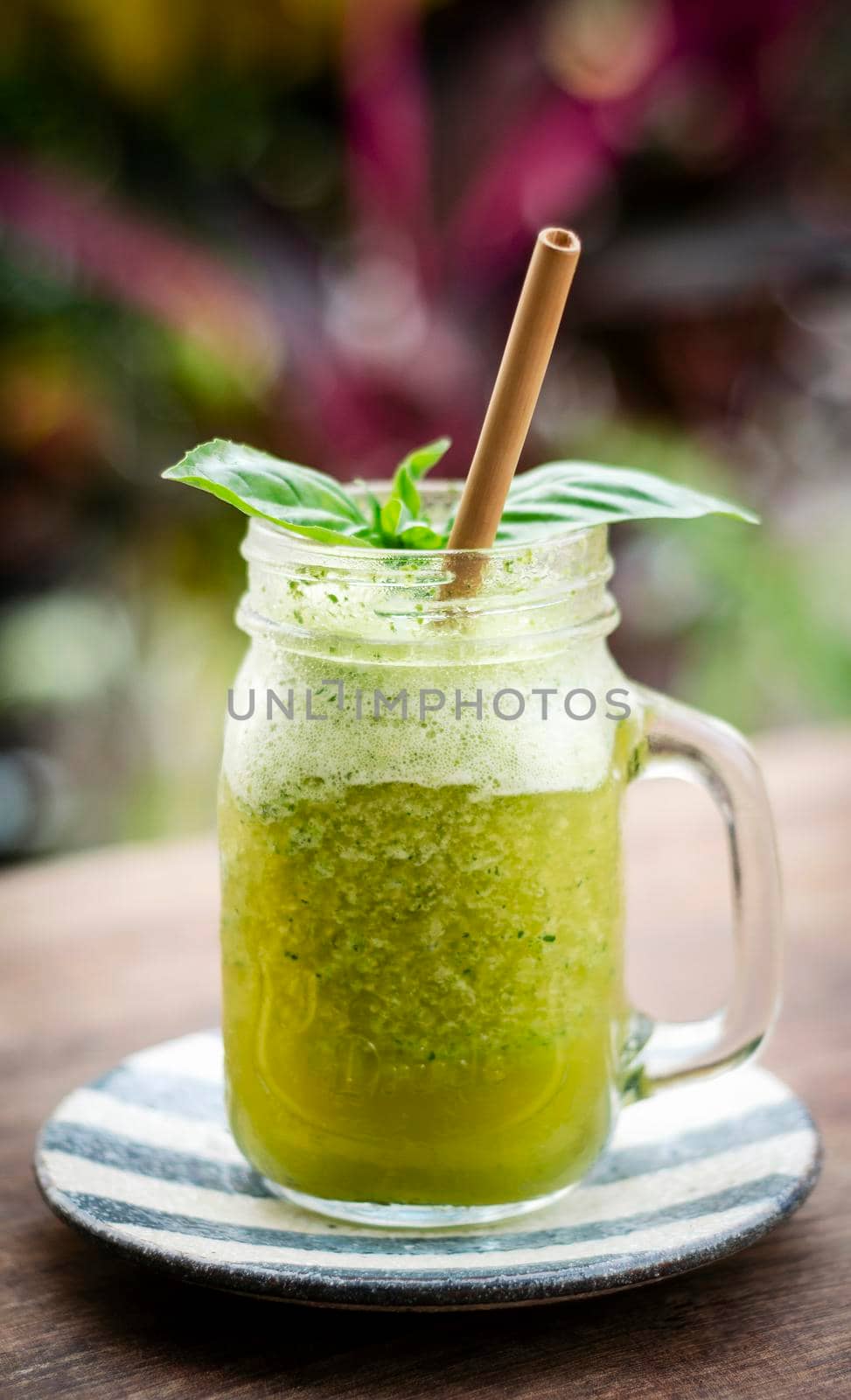 organic pineapple kiwi and basil fruit detox healthy smoothie drink outdoors in glass