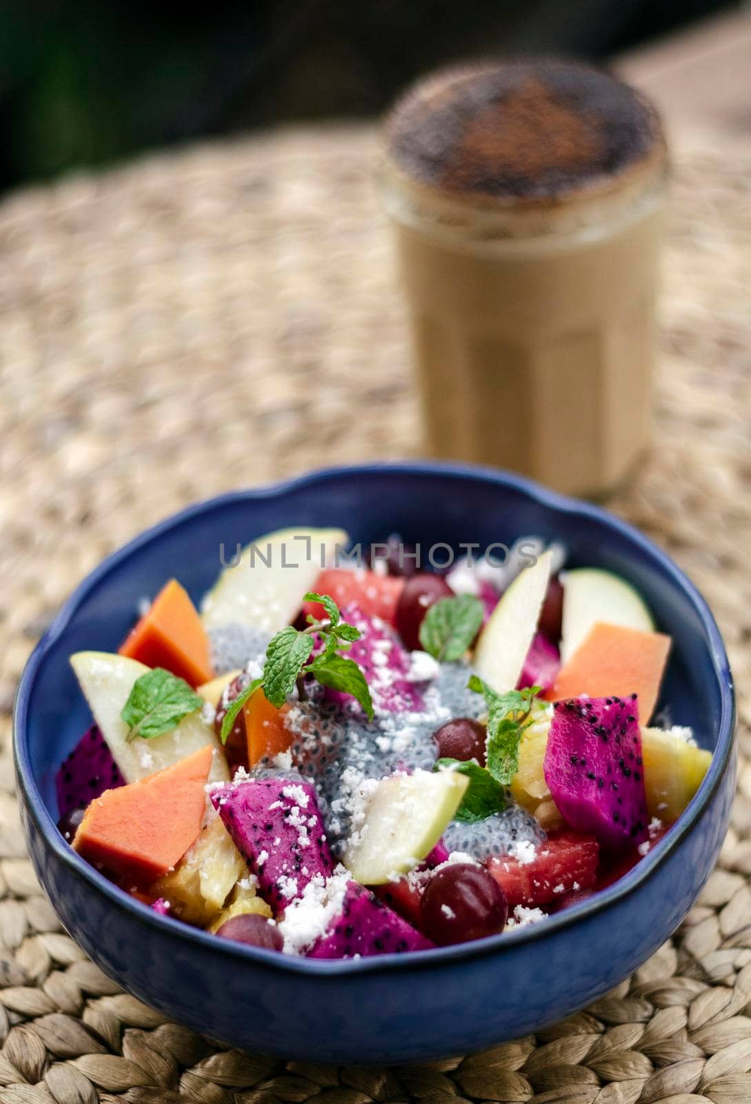 exotic mixed tropical asian fruit salad with basil seeds and coconut in bowl outdoors