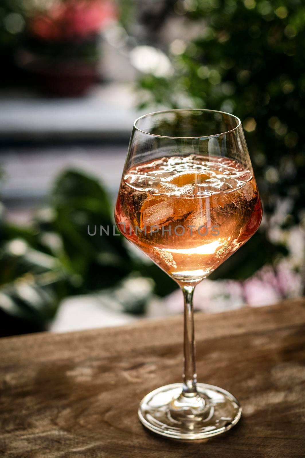 rose wine spritzer with orange cocktail drink on table outside by jackmalipan