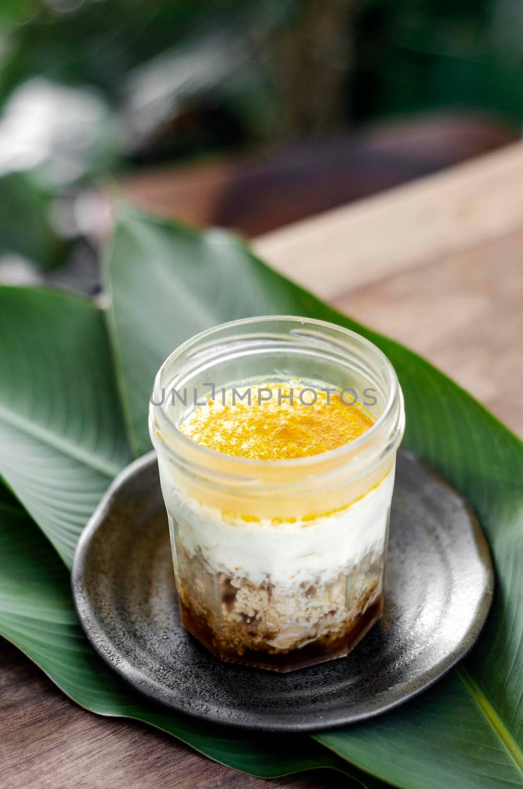 granola, coconut mousse, dates and turmeric powder healthy vegan dessert in rustic outdoors setting