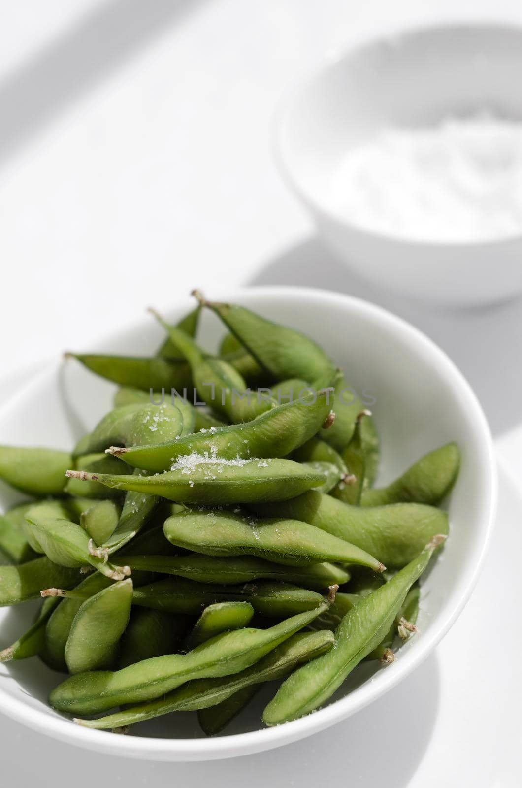 edamame beans snack in bowl on table with sea salt by jackmalipan