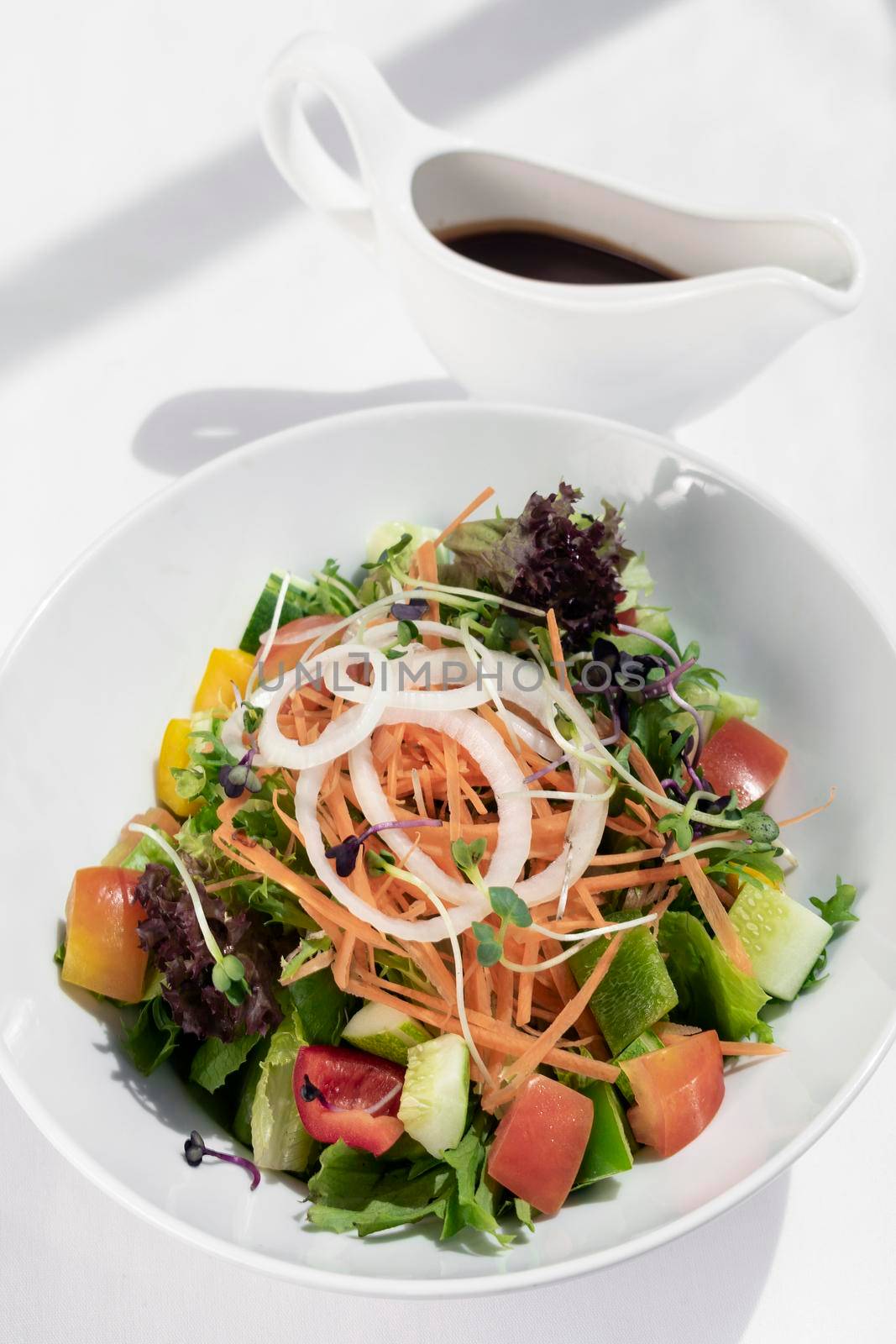 fresh organic mixed vegetable vegan Garden Salad with Vinaigrette sauce on white table