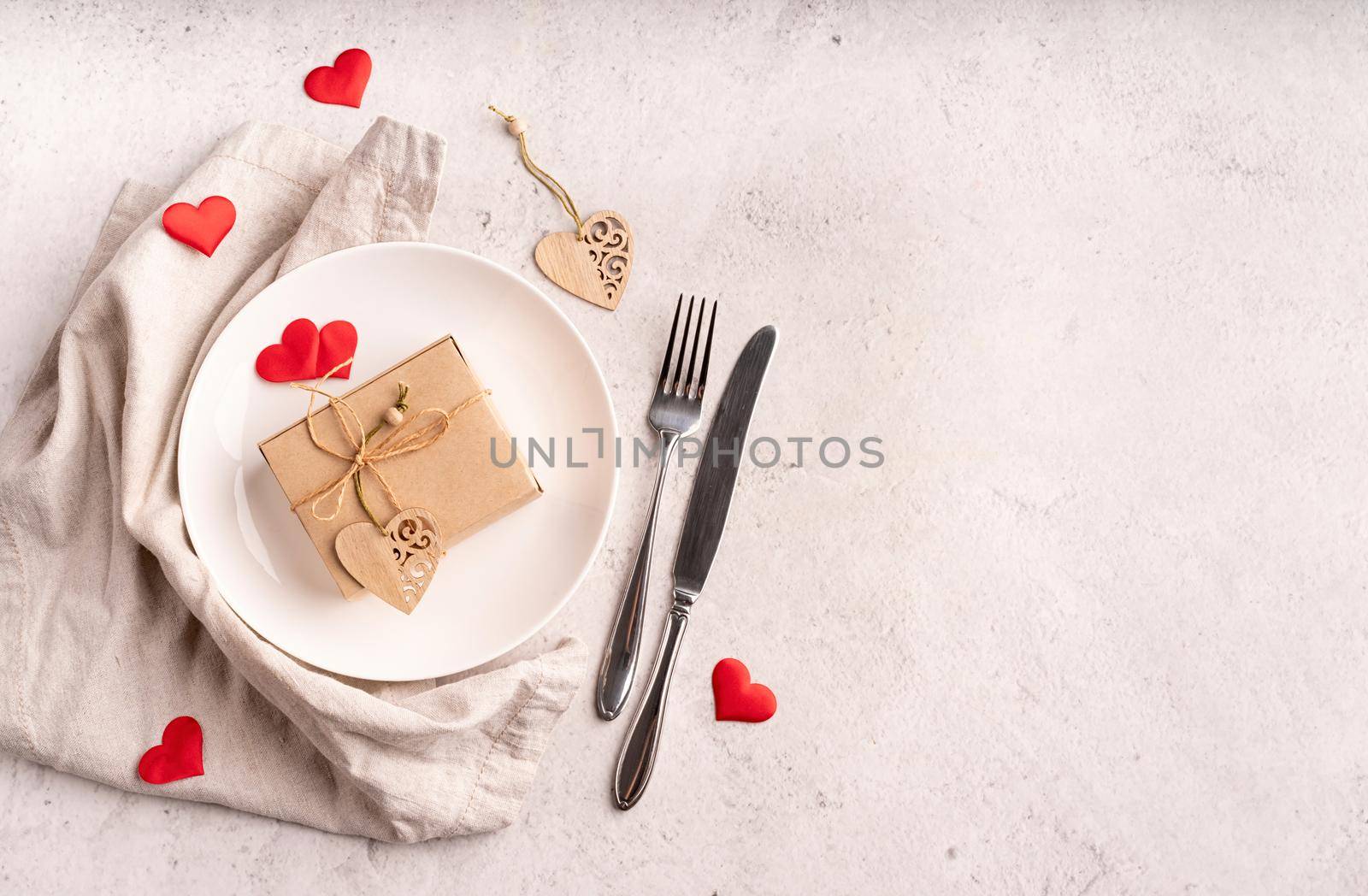 Valentines day table setting with an eco gift box, hearts, fork and knife top view with copy space by Desperada