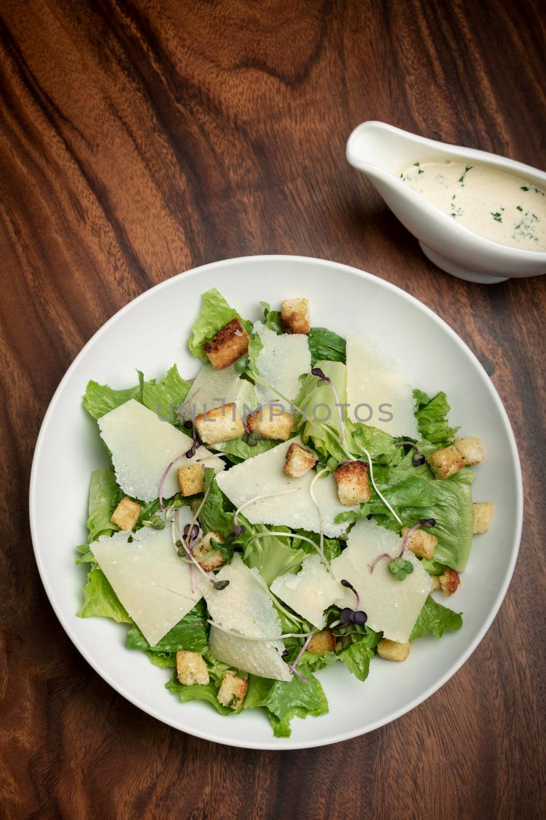 caesar salad with parmesan cheese and croutons on table by jackmalipan