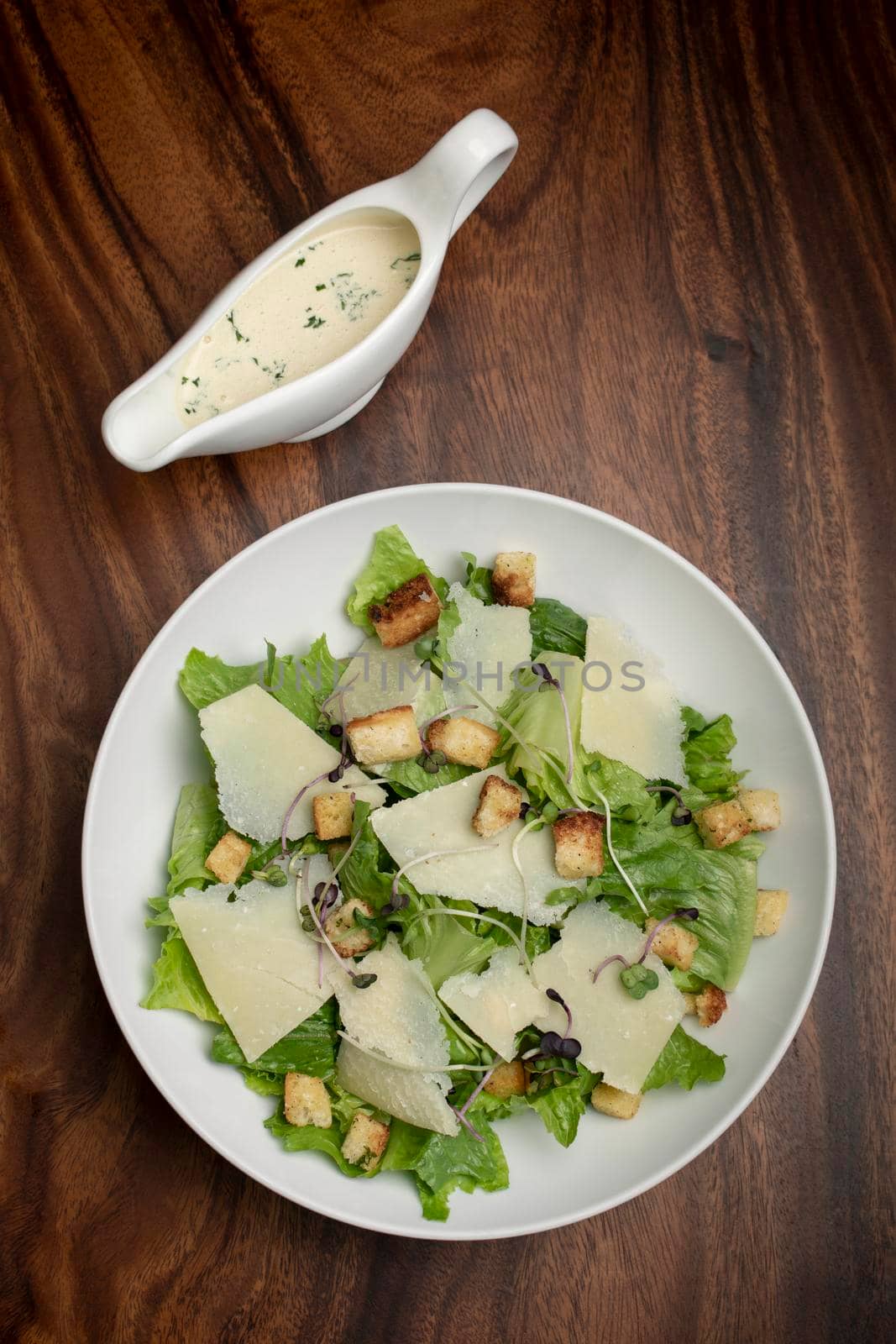 caesar salad with parmesan cheese and croutons on table by jackmalipan