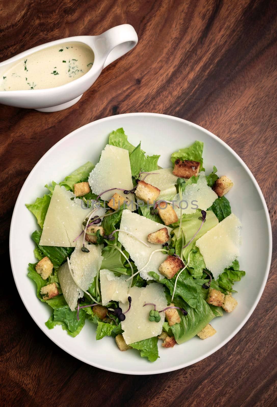 caesar salad with parmesan cheese and croutons on wood table