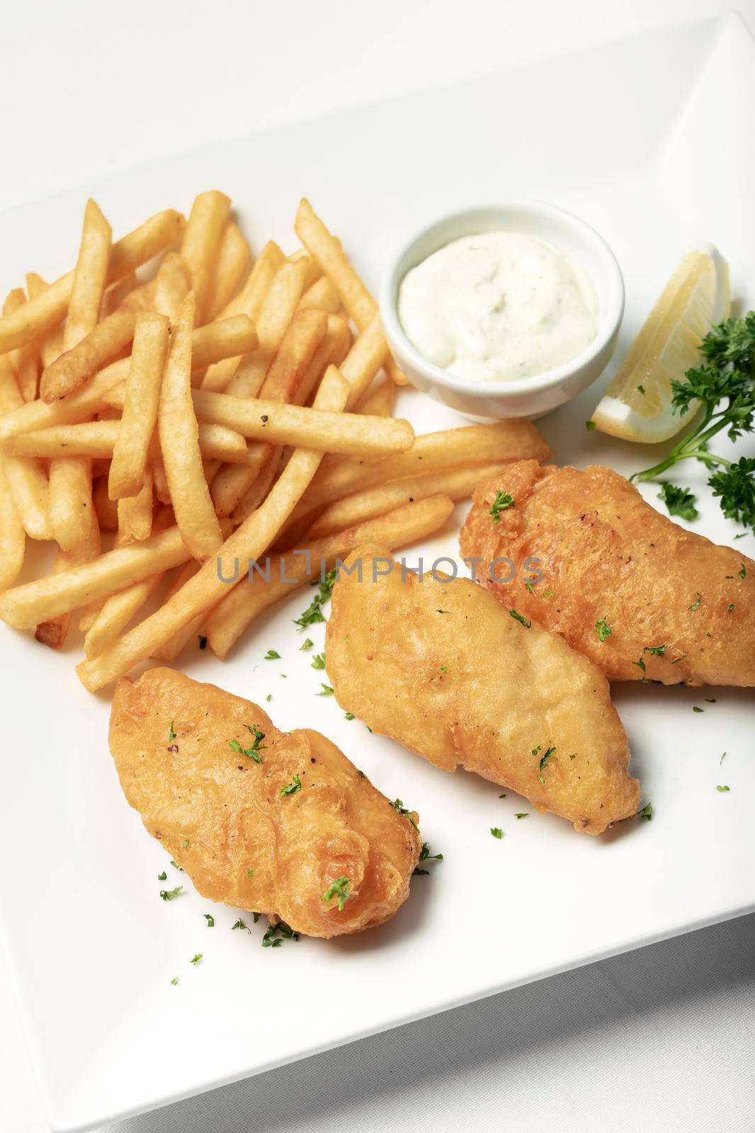 british traditional fish and chips meal on white plate