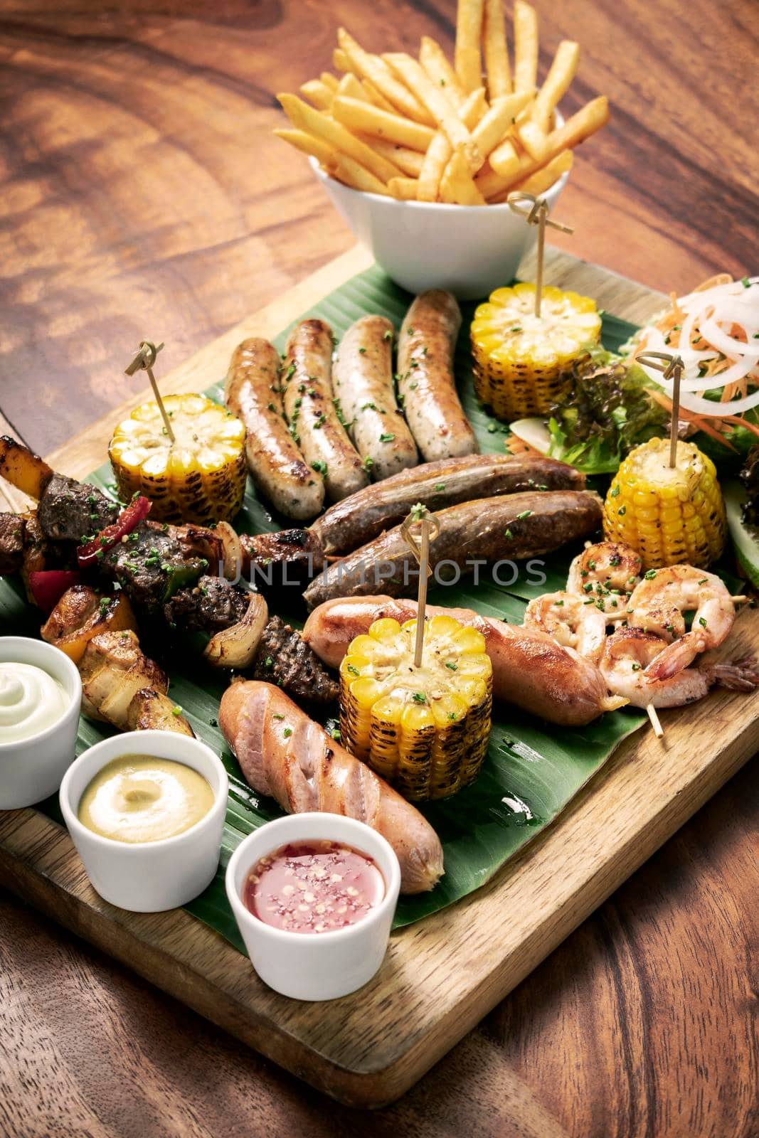 organic mixed grill barbecue meat platter rustic set meal with sausages, skewers, side dishes and sauces