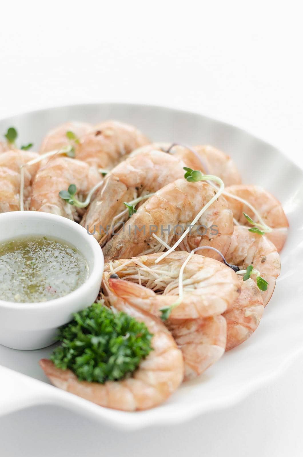 fresh boiled prawns with zesty citrus dipping sauce on white background