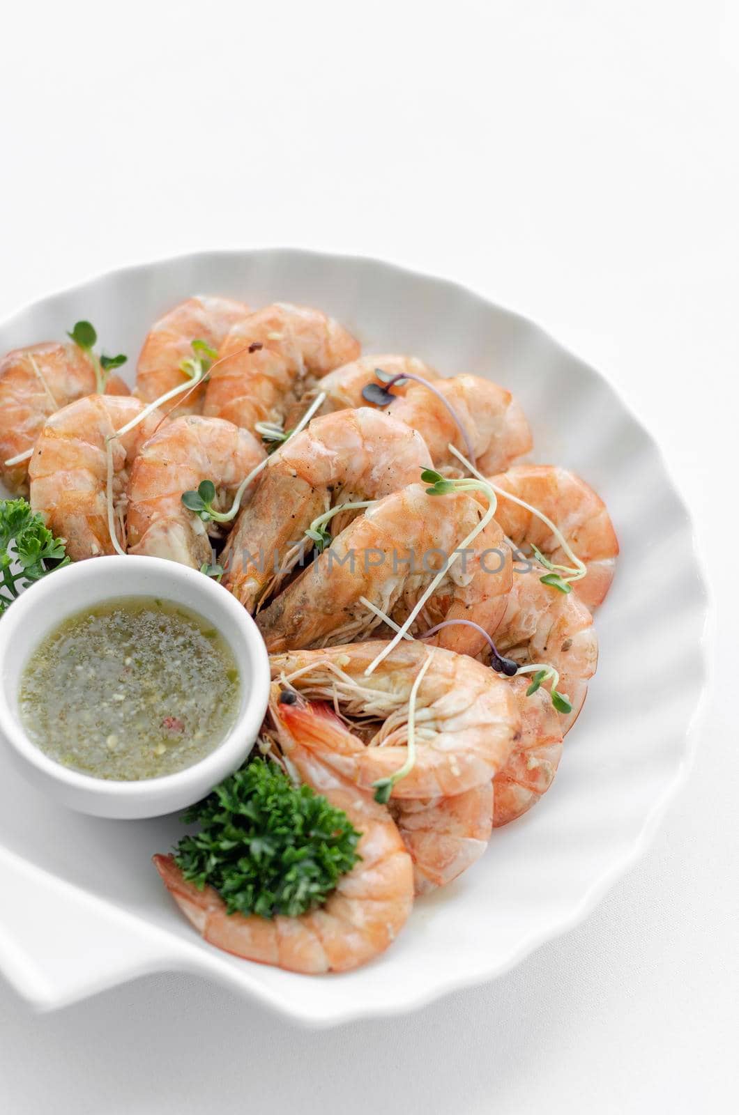 fresh boiled prawns with zesty citrus dipping sauce on white background