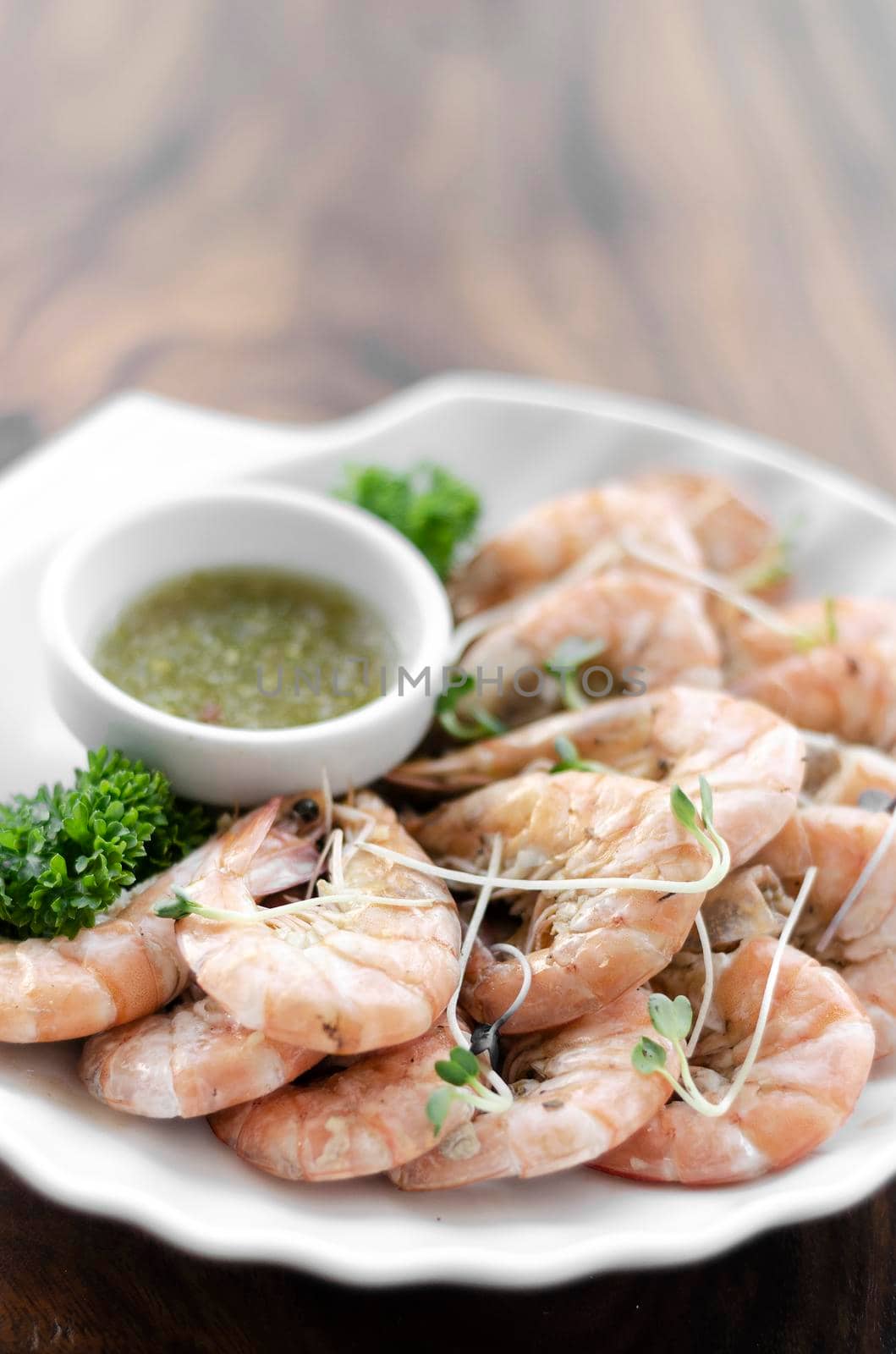 fresh boiled prawns with zesty citrus dipping sauce on wood table