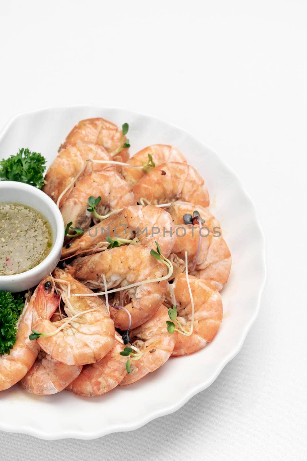 fresh boiled prawns with zesty citrus dipping sauce on white background