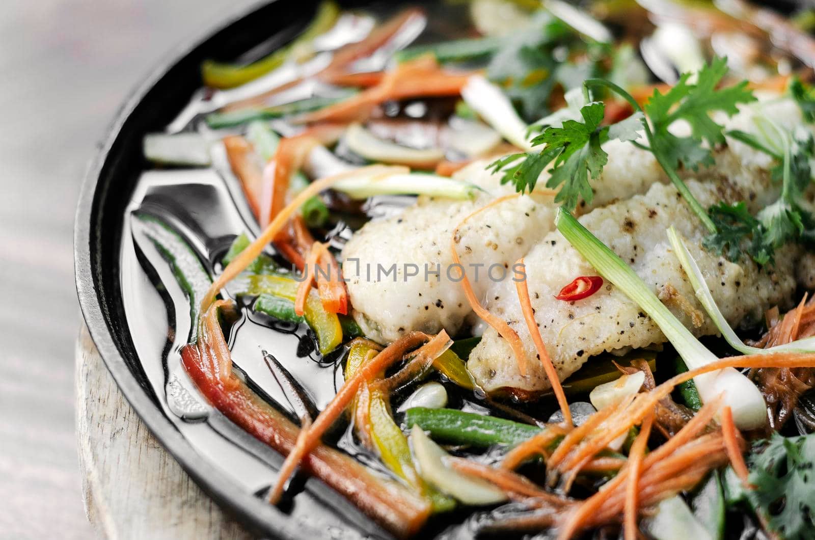 chinese style steamed fish fillet with vegetables on hot plate by jackmalipan