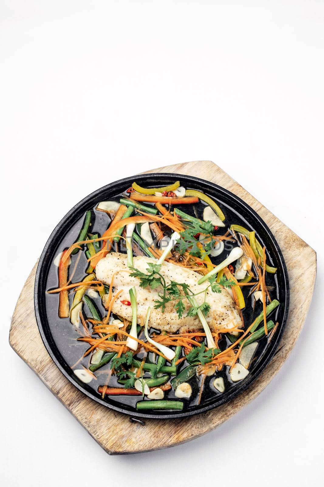 chinese cantonese style steamed spicy fish fillet with vegetables on hot plate