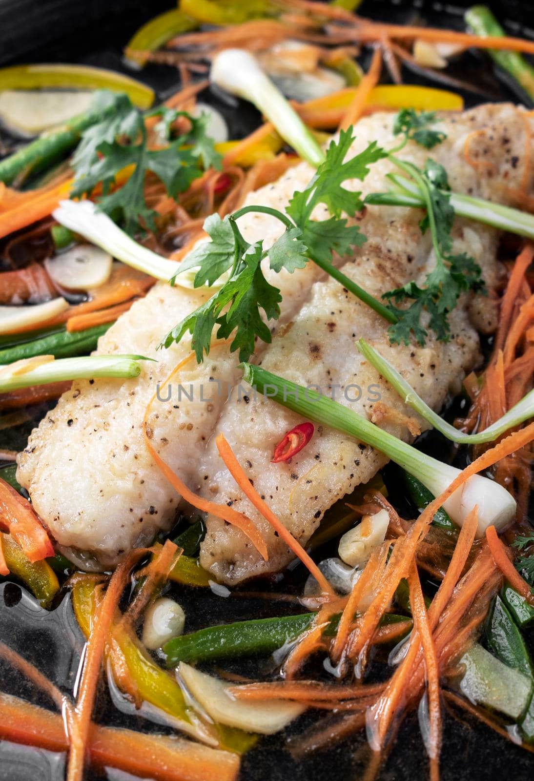 chinese style steamed fish fillet with vegetables on hot plate by jackmalipan