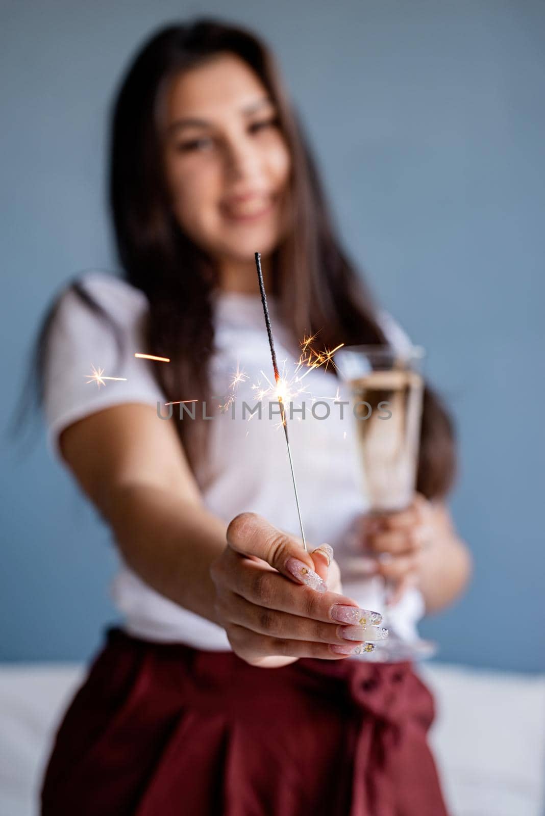 Valentines Day. Young brunette woman drinking champagne holding a sparkler
