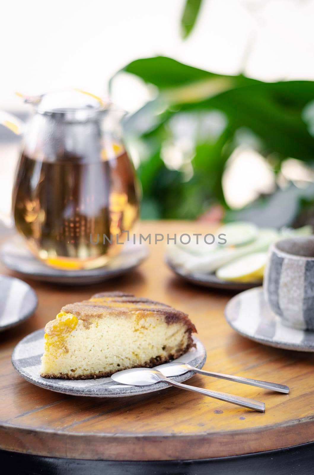 organic mango cake and herbal tea set on rustic cafe table outdoors