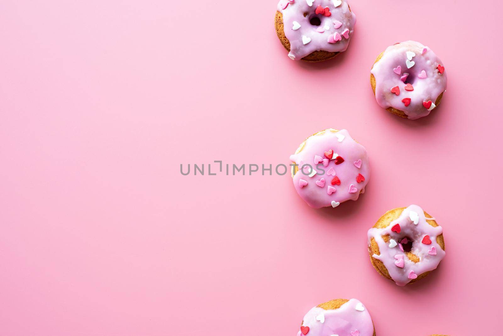 Small donuts isolated on pink background by Desperada