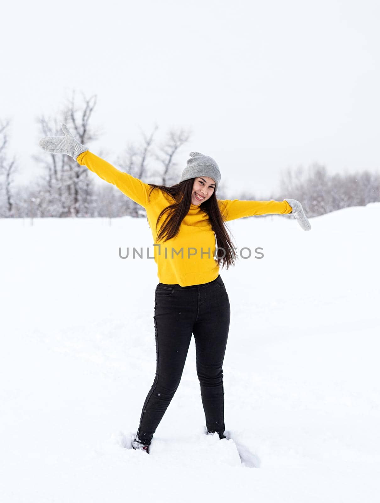 Young brunette woman playing with snow in park by Desperada