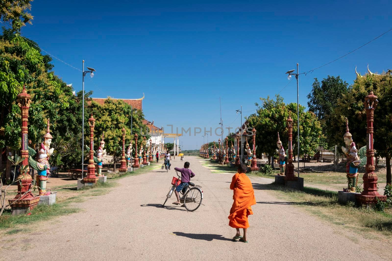 buddhist monk walking outside Wat Svay Andet Pagoda in Kandal Province Cambodia by jackmalipan