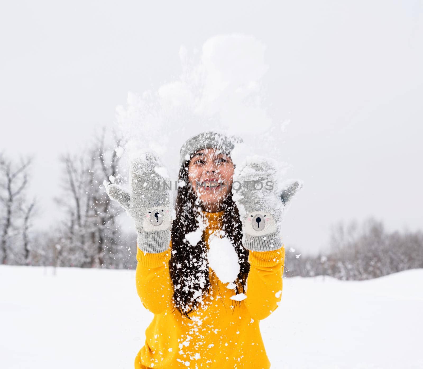 Outdoor concept. Young brunette woman playing with snow in park