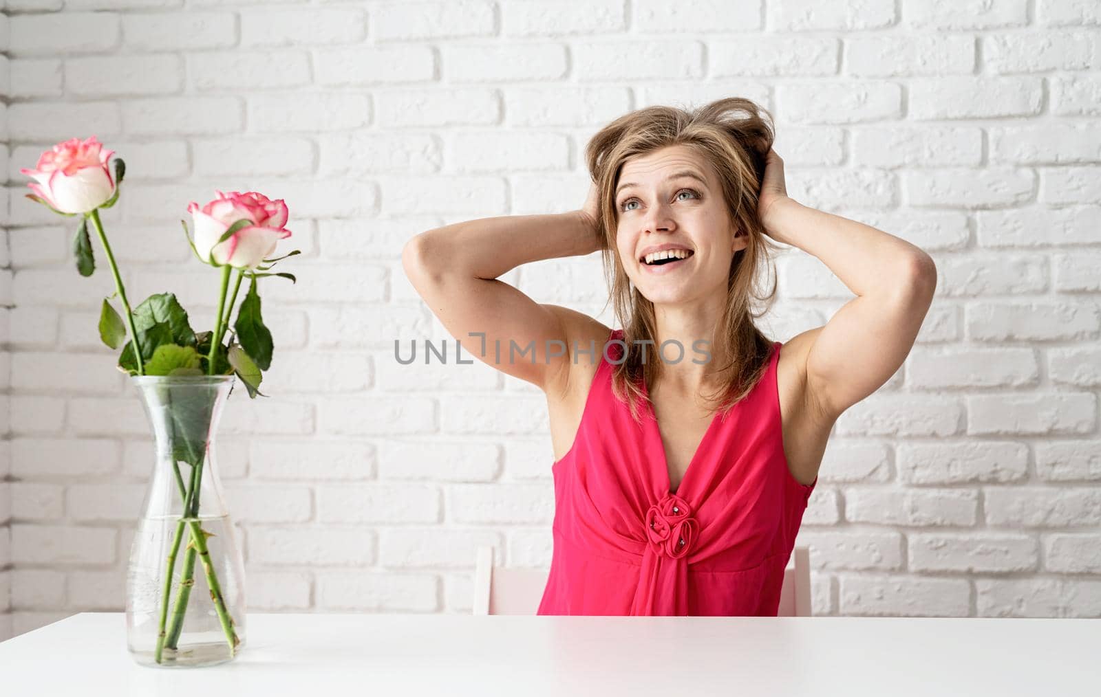 Happy young woman in pink dress daydreamimg or thinking about something nice by Desperada