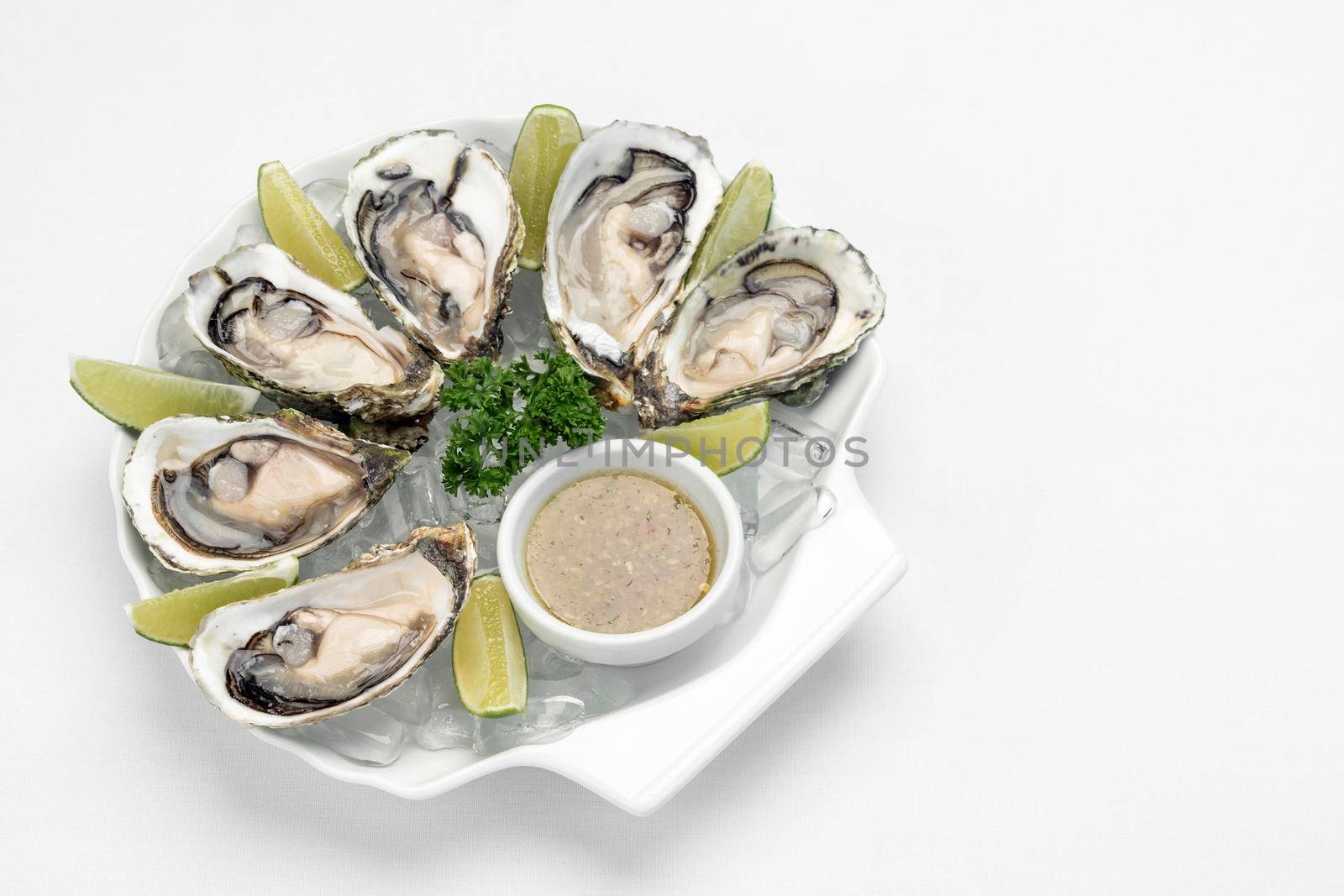 Six fresh oysters with lime wedges and citrus sauce by jackmalipan