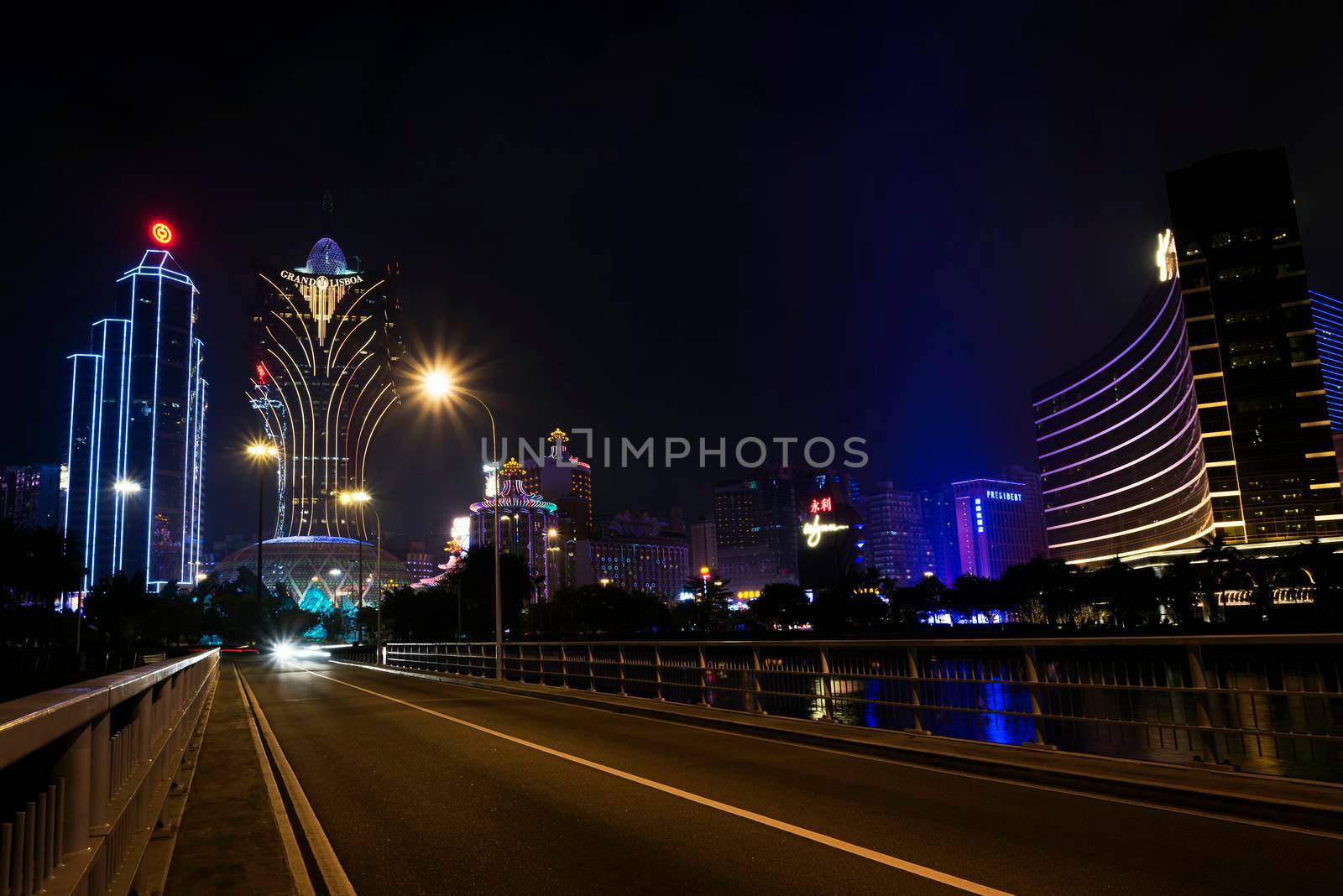 view of casino buildings at night in macau city china by jackmalipan