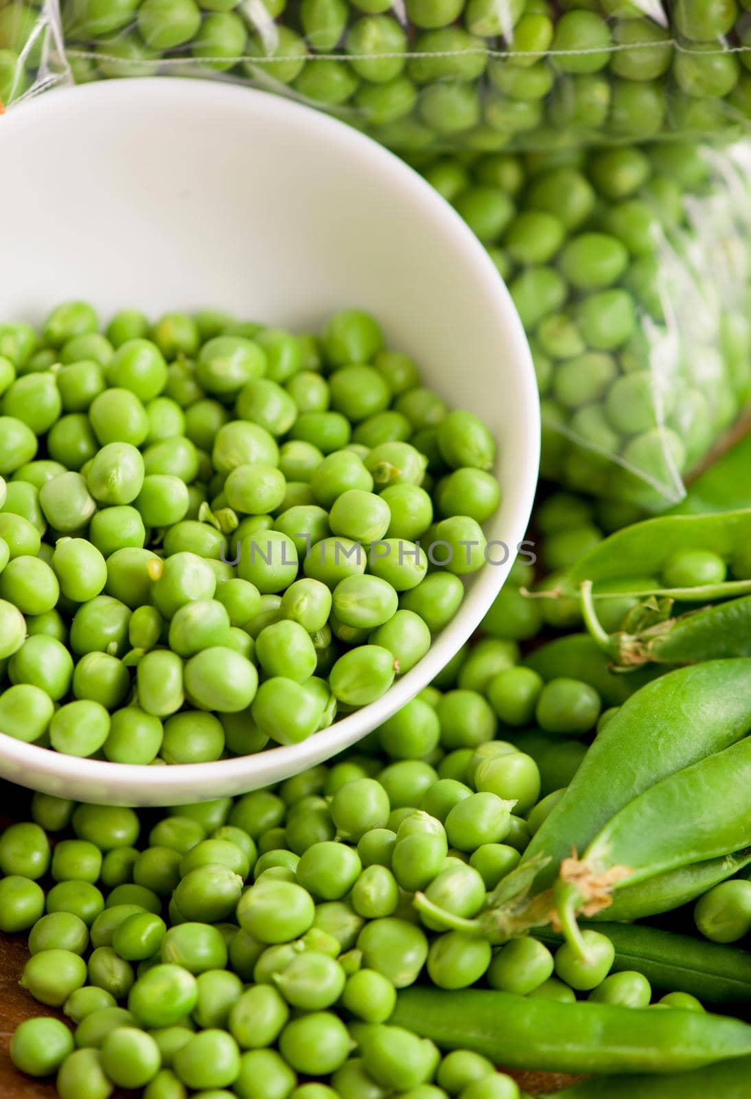 fresh green pea in bowl on wooden background.