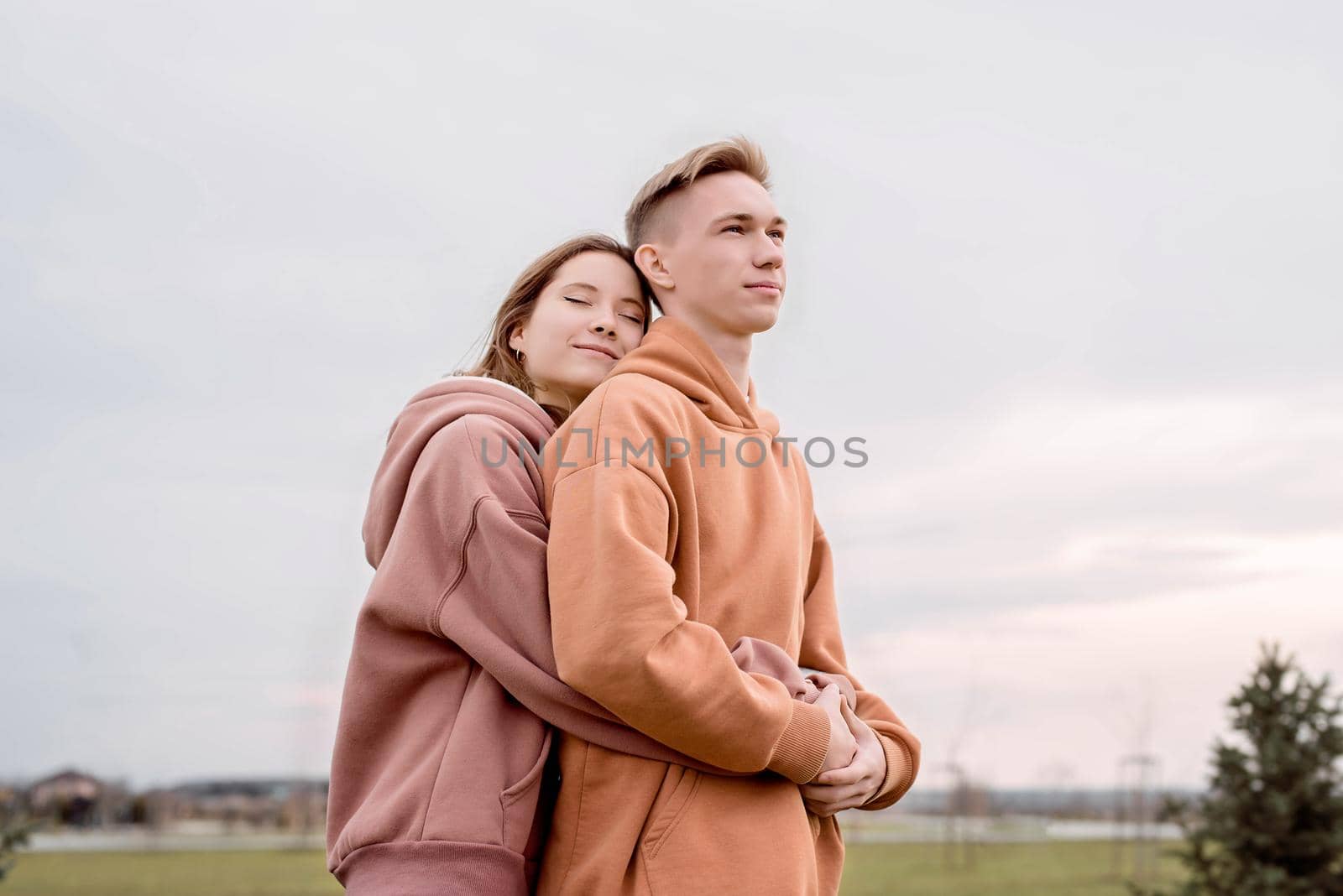 Happy young loving couple embracing each other outdoors in the park