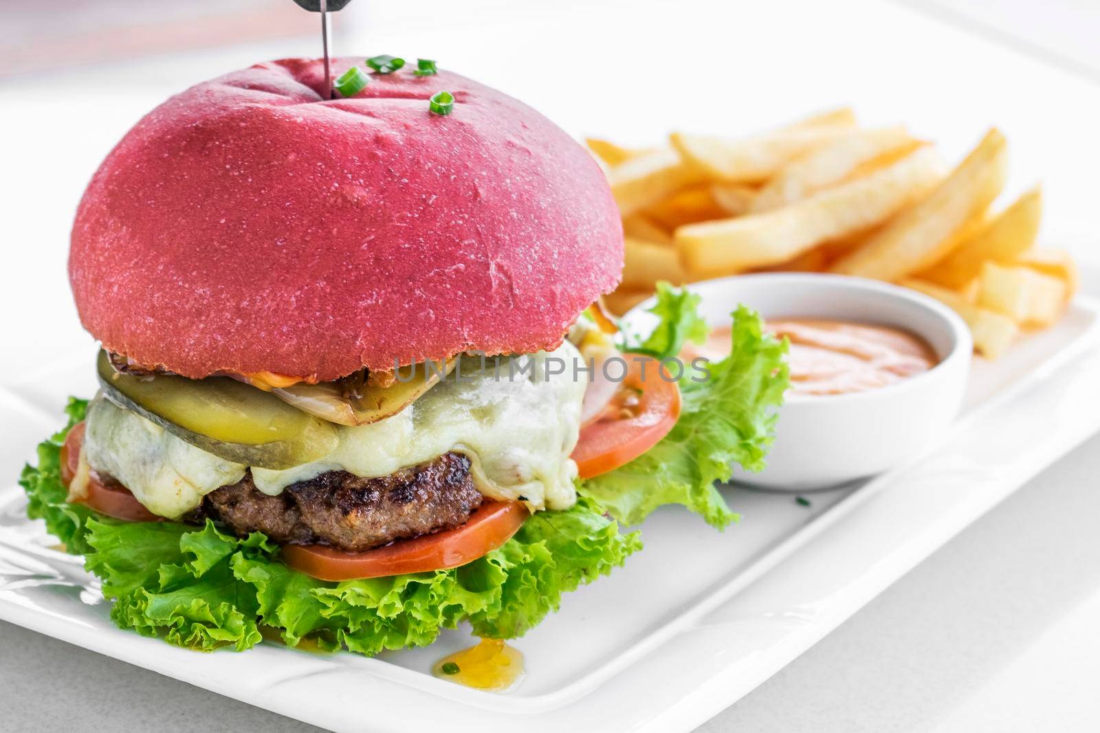 beetroot red bun cheese burger snack set with fries and chilli mayo on white plate