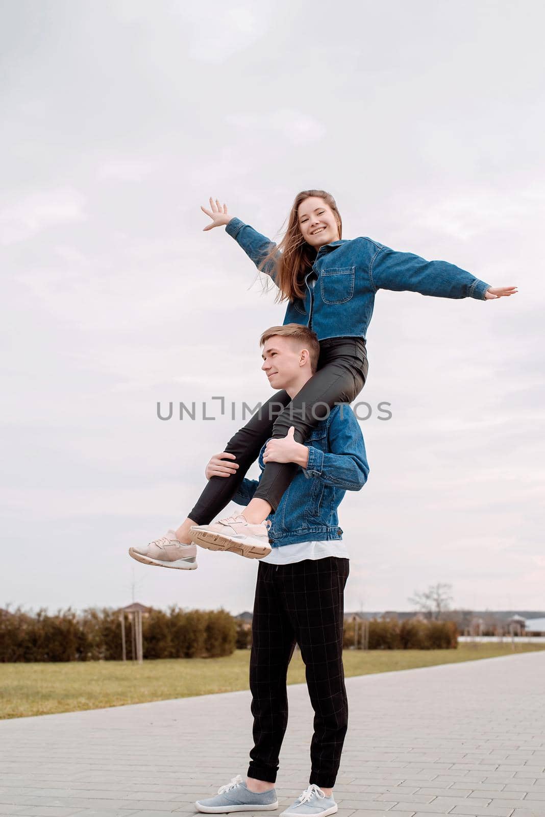 Young loving couple wearing jeans spending time together in the park having fun