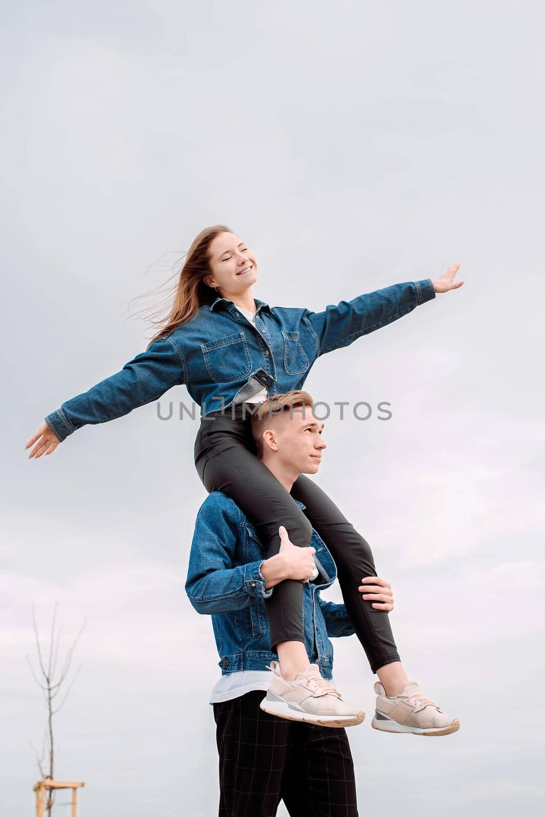 Young loving couple wearing jeans spending time together in the park having fun